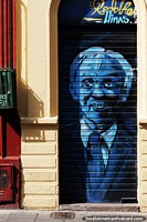 Blue man in a suit painted onto a rolling door of a shop in Bogota.