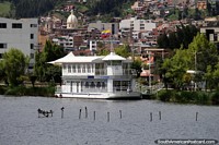 Vista de Paipa do outro lado do Lago Sochacota, barco de cruzeiro e uma igreja distante. Colômbia, América do Sul.