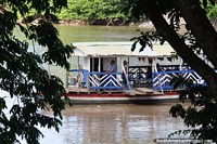 The wooden platform boats on the river are an icon of Monteria. Colombia, South America.