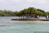 Turquoise waters and seating under shady trees at Tintipan Island. Colombia, South America.