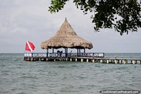 Embarcadero con zona de asientos bajo techo de paja, mar abierto alrededor, isla Tintipán. Colombia, Sudamerica.