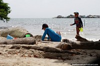 Children play in the sand on one of the many beaches in the bays of Tintipan Island. Colombia, South America.