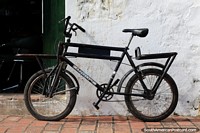 An antique bicycle leans against a wall outside an antique shop in Mompos. Colombia, South America.