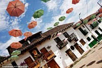 Rua dos guarda-chuvas em San Agustín, vista espetacular com guarda-chuvas rosa e verdes acima. Colômbia, América do Sul.