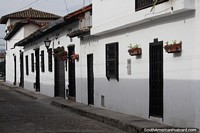 Street and houses in Giron with white-washed walls and flower pots, 10kms from Bucaramanga. Colombia, South America.
