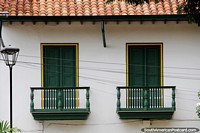 Twin balconies and doors below a tiled roof, a nice building at the plaza in San Gil. Colombia, South America.