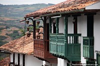 Grandes balcones de madera decorados con vistas a las verdes colinas y las tierras de cultivo de Barichara. Colombia, Sudamerica.