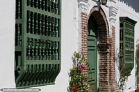 Versão maior do Edifício caiado de branco com portas e janelas de madeira, bela arquitetura em Santa Fé de Antioquia.