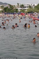 People enjoy cooling off at the beach on a hot day in Santa Marta.