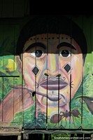 Hombre indígena con una cuchara, una hormiga debajo, mural en el costado de una casa en Mocagua, cerca de Leticia. Colombia, Sudamerica.