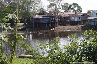 Community of houses on stilts built close together beside the river in Leticia. Colombia, South America.