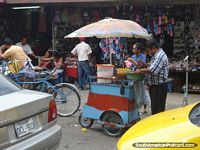 Uma tina de suco de coco frio como gelo, compre alguns em uma bolsa plástica com a palha, Machala. Equador, América do Sul.