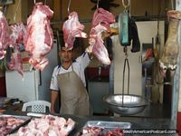 Larger version of A butcher in the Machala meat markets poses for a picture.