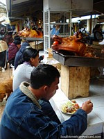The Otavalo food market has freshly made pork meals to eat. Ecuador, South America.
