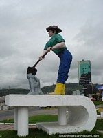 Homem com pá e monumento de cimento em Tulcan. Equador, América do Sul.