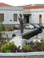 Big black cannon and statue guard at military college in Quito. Ecuador, South America.