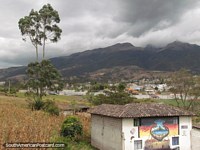 Pintura mural en una pared de la casa, colinas y granjas al sur de Otavalo. Ecuador, Sudamerica.