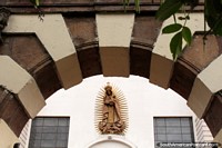 An archway and a gold figure at the cathedral beside Parque Juan Montalvo in Ambato. Ecuador, South America.