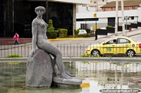 A female statue figure sitting on a rock in water in Ambato.