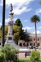 The central monument at Parque Maldonado and a palm tree in Riobamba. Ecuador, South America.