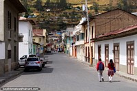 O rapaz e a menina andam em uma rua no centro da cidade de Alausi. Equador, América do Sul.