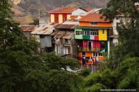 Uma pilha de casas de muitas cores entre a cidade e a ponte em Alausi. Equador, América do Sul.