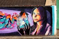 A bonita mulher mantém uma lanterna mágica, mural de rua em Alausi. Equador, América do Sul.