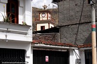 The church clock tower seen from a street nearby in Alausi. Ecuador, South America.