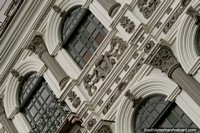 Versión más grande de La fantástica fachada de un edificio con ventanas de arco y diseño intrincado en Cuenca.