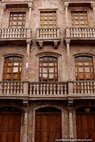 A brown stone facade with wooden doors and windows in Cuenca. Ecuador, South America.