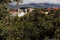 View of a church and the college roof with distant hills in Cuenca.