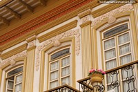 Versión más grande de Bonita fachada de oro y ventanas con flores de color rosa en una olla, de Cuenca.