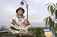 Monument of a woman sitting cross-legged opposite Mercado Rosalino Ruiz Arroyo in Pujili.