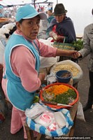 Larger version of A woman prepares chopped vegetables for cooking at the market in Pujili.