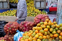 Um caminhão transborda com laranjas que esvaziam as costas no mercado de Saquisili. Equador, América do Sul.