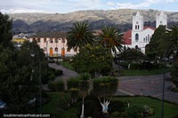 The central plaza and park in Saquisili with views of the church and surrounding hills. Ecuador, South America.