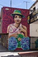 Mujer en un sombrero verde sostiene un colgante, mural en Machachi. Ecuador, Sudamerica.