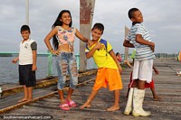 Crianças locais de San Lorenzo que posa para a câmera, divertimento no porto e cais. Equador, América do Sul.