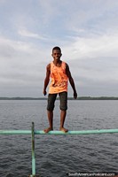 Young man getting ready to perform a backwards somersault off the wharf in San Lorenzo. Ecuador, South America.