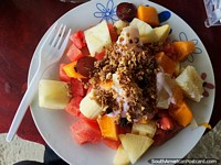 Fruit salad in Canoa with banana, papaya, watermelon, grapes, pineapple, muesli and yogurt, yummy! Ecuador, South America.