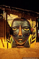 Large mural of an indigenous face with ear and nose piercings in Montanita. Ecuador, South America.