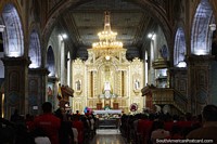 Um serviço em balança cheia na catedral em Loja com deslumbramento de luz de ouro. Equador, América do Sul.