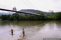 As crianças brincam no rio Zamora, em Yantzaza, na Praia Rica, do outro lado da ponte da cidade. Equador, América do Sul.