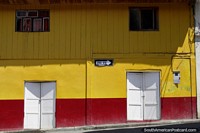 Fachada amarelo-viva de um edifïcio de madeira em Limon, cidade ao sul de Macas. Equador, América do Sul.