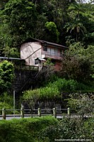A casa de madeira rosa em uma colocação bonita rodeia-se de árvores em Limon. Equador, América do Sul.