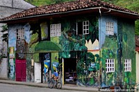 Tienda de madera y casa pintada con imágenes de naturaleza y cultura en Limón. Ecuador, Sudamerica.