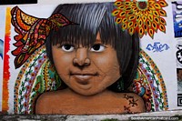 Larger version of Technicolor bird and a rainbow of color around an indigenous boy, street art by Isaac and Bejeno in Macas.