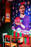 Large purple mural of a woman holding a rose in Banos at Alomeromero Restaurant. Ecuador, South America.