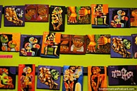 A wall of interesting and colorful art prints in the arts and crafts shops of Banos. Ecuador, South America.
