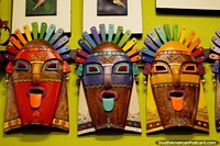 3 máscaras de madera con pelo de punta, lengüetas y aretes, artesanías de pared en Banos. Ecuador, Sudamerica.